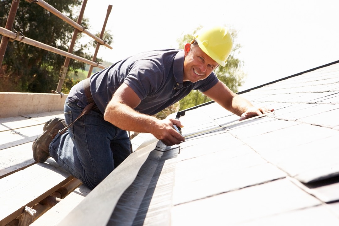 Roofer installing asphalt shingles on a roof