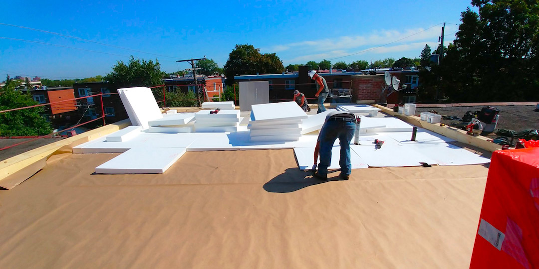 Workers installing a TPO membrane designed for a terrace roof