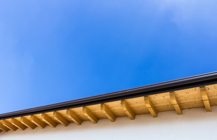 Vue d'une gouttière de toit plan avec le ciel bleu au-dessus.