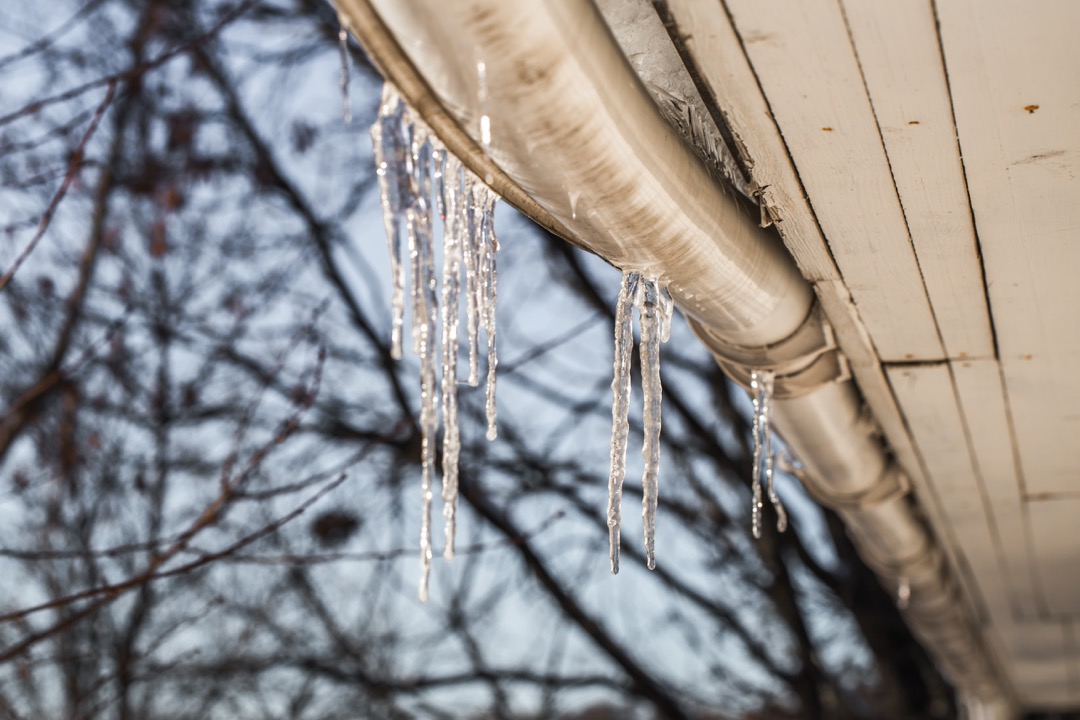 ice icicles on the roofs of a house.