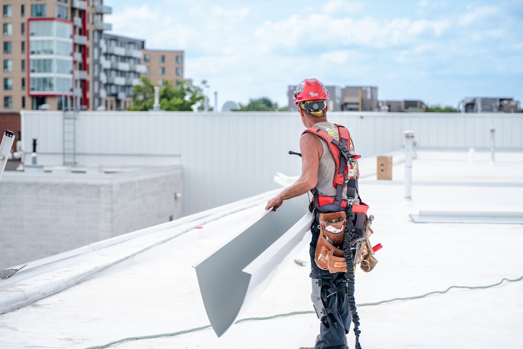 Worker on the insulation of an industrial roof.