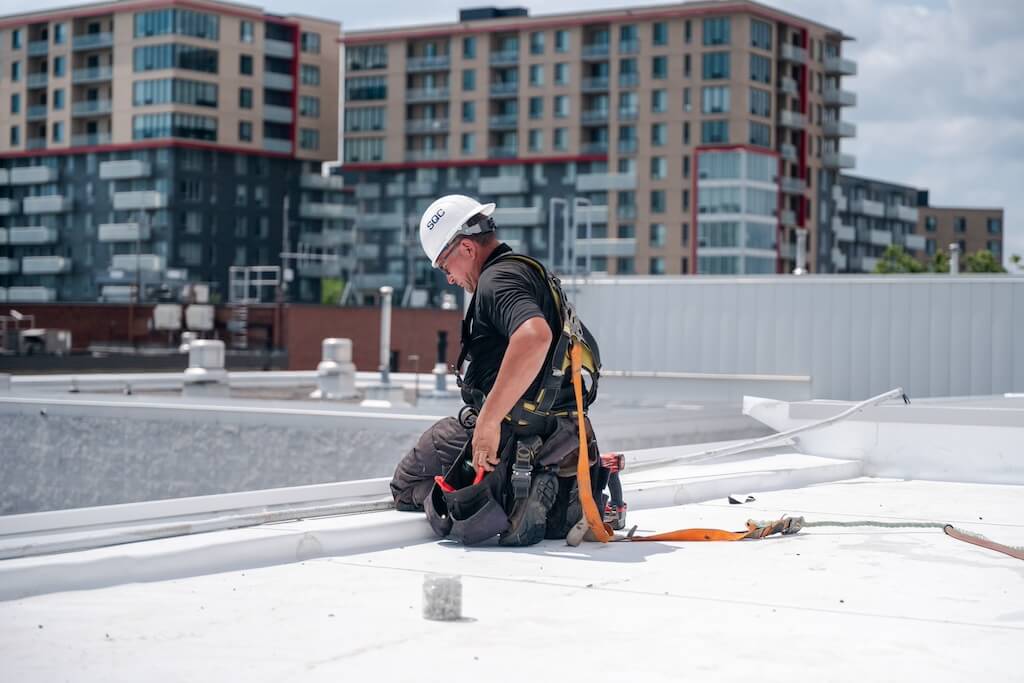 Worker on the insulation of an industrial flat roof.