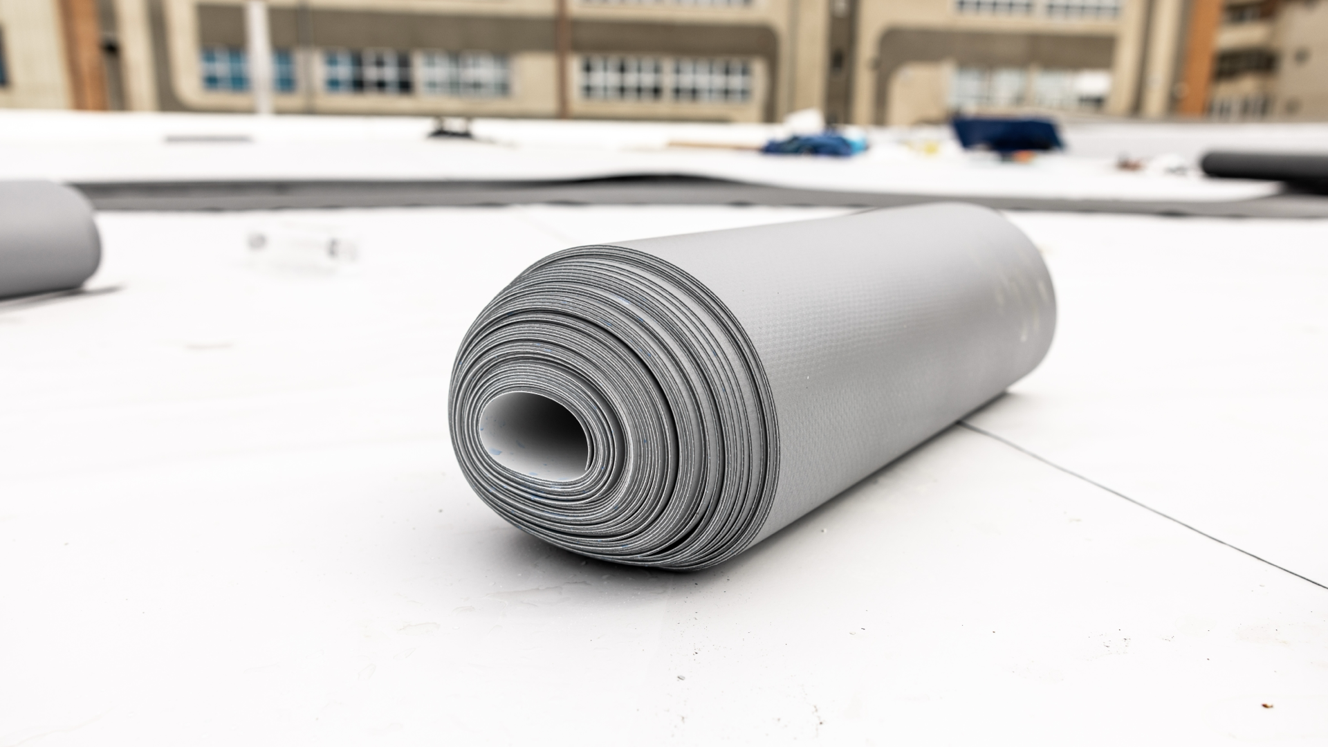 Roll of TPO membrane laid on a flat roof.